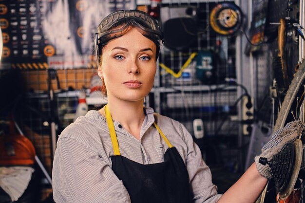 Free photo portrait of female bicycle mechanic over tool stand background.