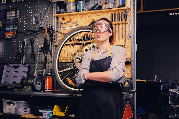 ツールスタンドの背景上の女性の自転車整備士の肖像画。
