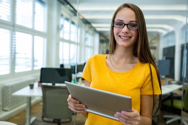 Portrait of female business executive holding digital tablet