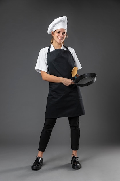 Portrait female chef with pan