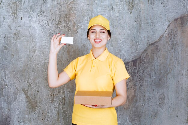 Портрет женского курьера, держащего карточку с картонной коробкой