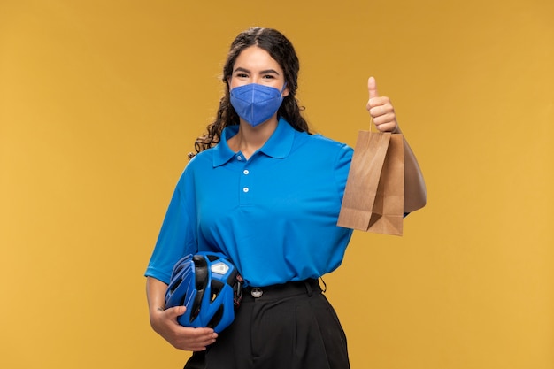 Free photo portrait of female deliverer showing thumbs up