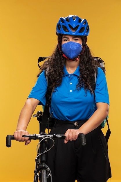 Portrait of female deliverer with bicycle and backpack