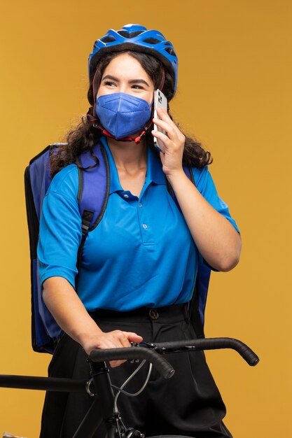 Portrait of female deliverer with bicycle and backpack