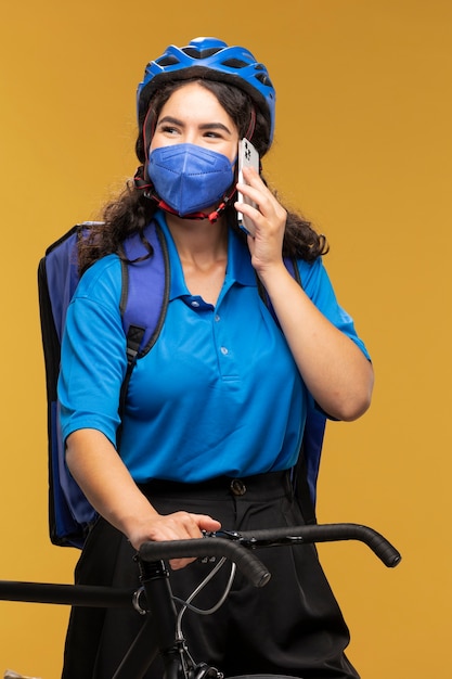 Portrait of female deliverer with bicycle and backpack