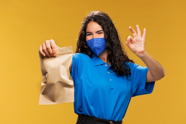 Free photo portrait of female deliverer with medical mask on