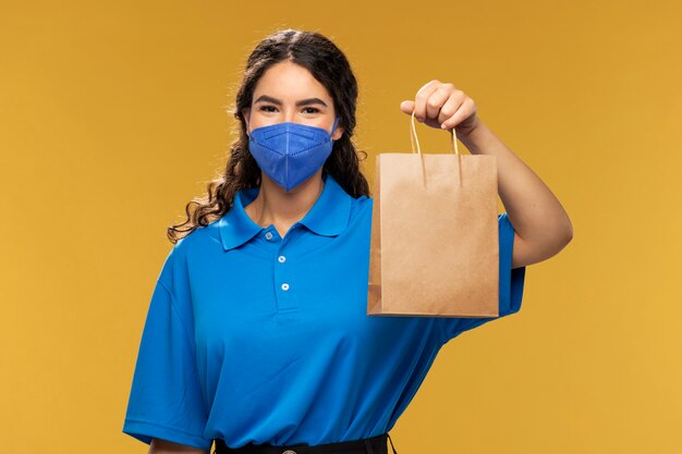 Free photo portrait of female deliverer with medical mask on