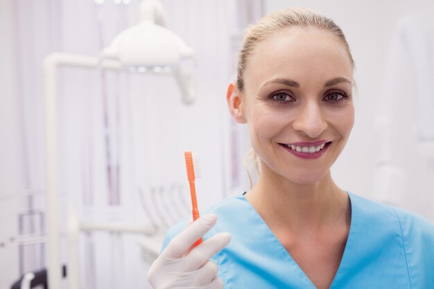 Portrait of female dentist holding toothbrush