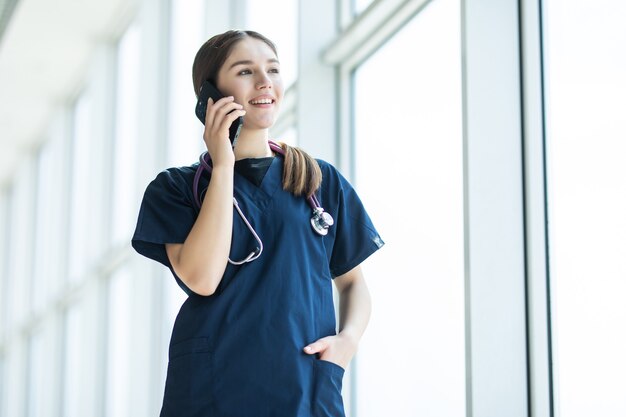 彼女の病院のオフィスで携帯電話を使用して女性医師の肖像画