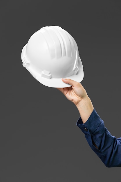 Portrait female engineer holding helmet close up