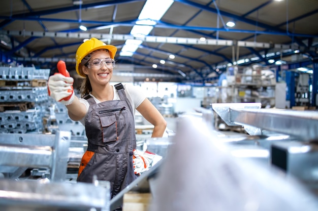 Portrait of female factory worker holding thumbs up