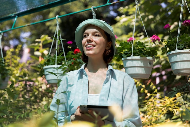 Free photo portrait of female farmer working in her greenhouse