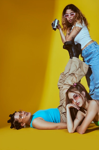 Portrait of female friends in 2000s fashion style posing together with camera