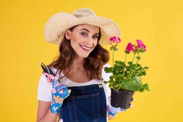 植木鉢で花を剪定する女性の庭師の肖像画