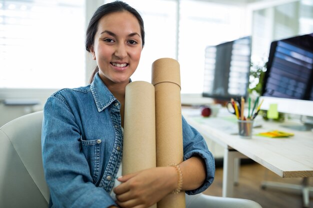 Portrait of female graphic designer holding chart holder