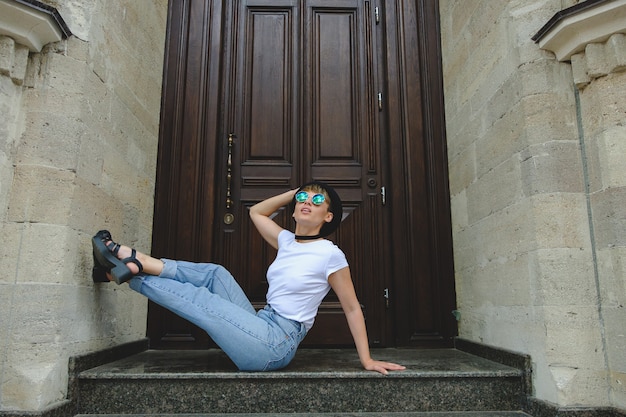 Foto gratuita ritratto dei pantaloni a vita bassa femminili con trucco naturale e breve taglio di capelli che godono del tempo libero all'aperto