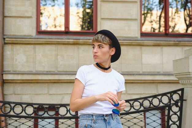 Portrait of female hipster with natural makeup and short haircut enjoying leisure time outdoors