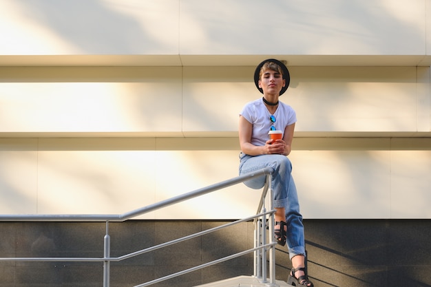 Portrait of female hipster with natural makeup and short haircut enjoying leisure time outdoors