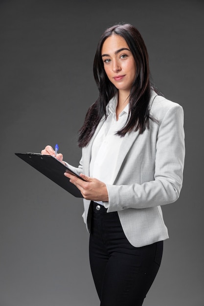 Free photo portrait female lawyer in formal suit with clipboard