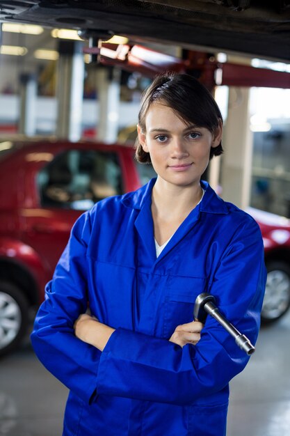 Portrait of female mechanic standing with arms crossed