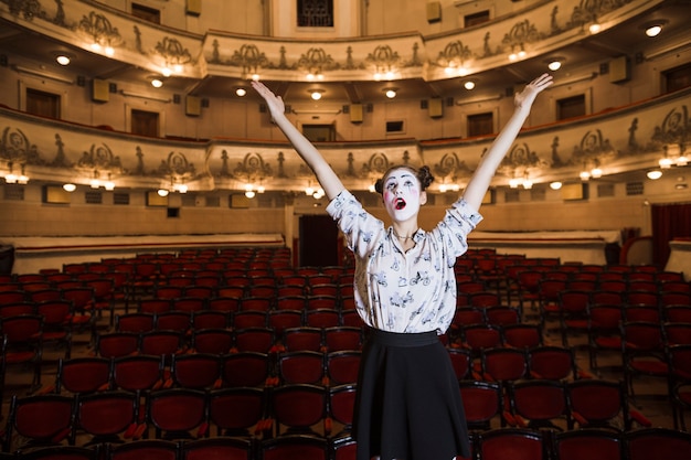 Portrait of female mime raising her hands looking up