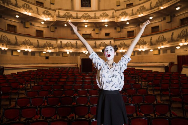 portrait of female mime raising her hands looking up