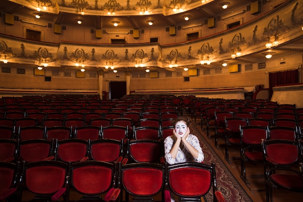 Portrait of a female mime sitting on chair