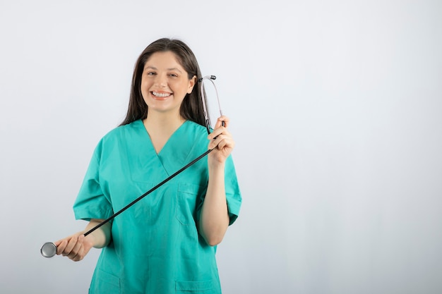 Portrait of female nurse with stethoscope posing on white. 