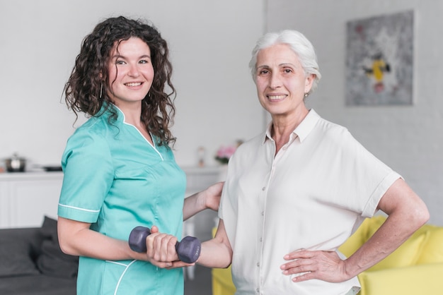 Portrait of female physiotherapist and senior woman patient exercising