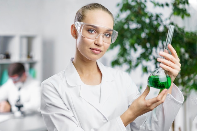 Free photo portrait of female researcher in the lab with test tube