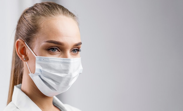Free photo portrait of female researcher with medical mask and copy space