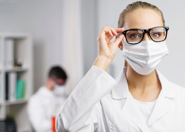 의료 마스크와 실험실에서 여성 과학자의 초상화