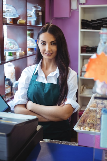 Portrait of female shopkeeper standing at turkish sweets counter