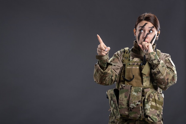 Ritratto di donna soldato in uniforme militare muro scuro