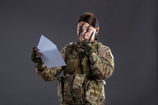 暗い壁に手紙を読んで女性兵士の肖像画