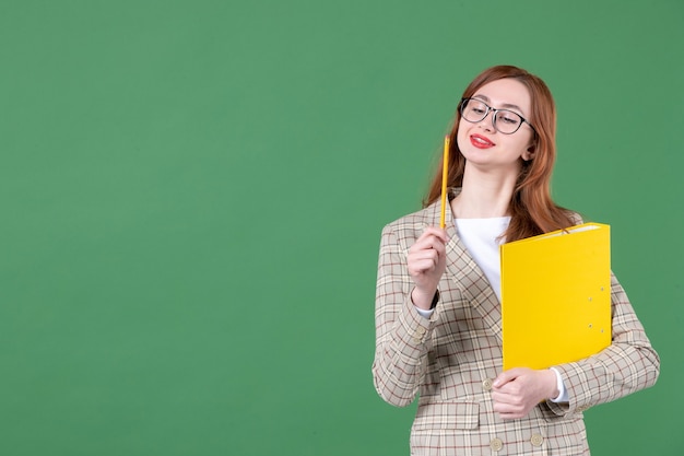 Ritratto di insegnante donna con documento giallo su verde