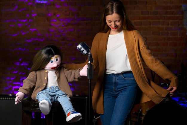 Portrait of female ventriloquist during show with puppet