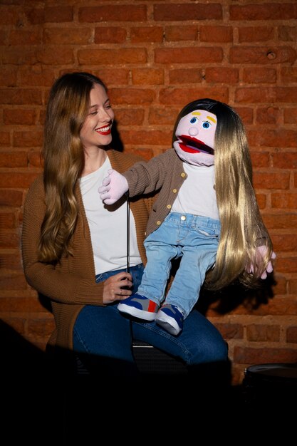 Portrait of female ventriloquist with puppet at show