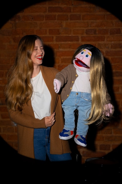 Portrait of female ventriloquist with puppet at show