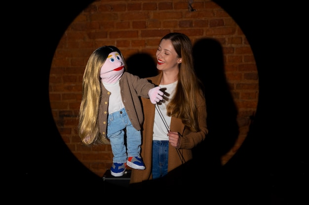 Free photo portrait of female ventriloquist with puppet at show