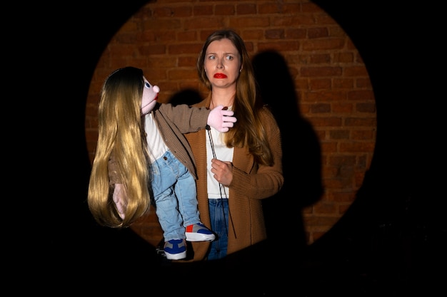 Portrait of female ventriloquist with puppet at show