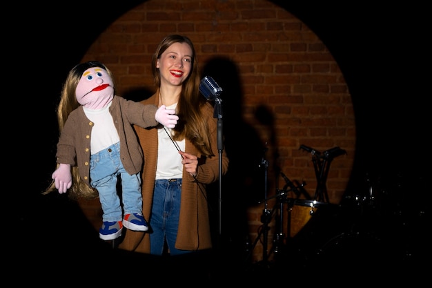 Portrait of female ventriloquist with puppet at show