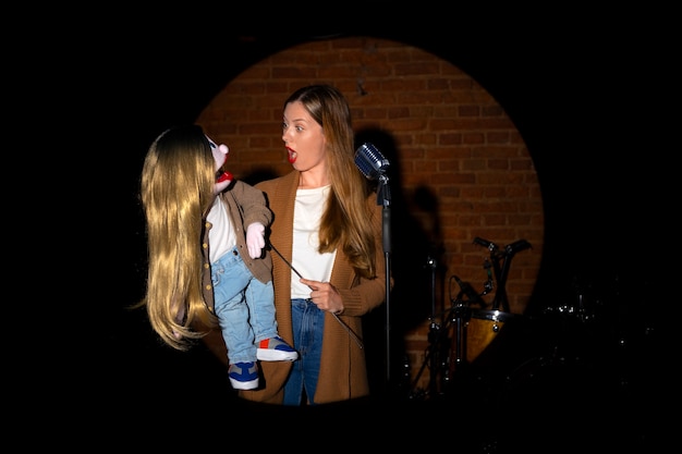 Portrait of female ventriloquist with puppet at show