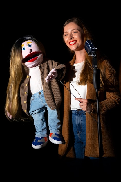 Portrait of female ventriloquist with puppet at show