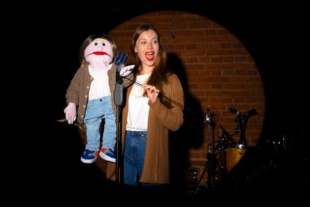 Portrait of female ventriloquist with puppet at show