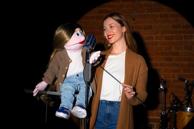 Portrait of female ventriloquist with puppet at show