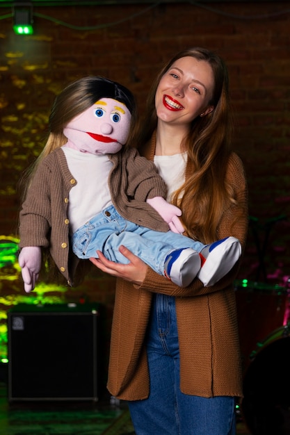 Portrait of female ventriloquist with puppet at show