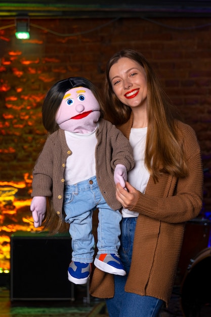 Portrait of female ventriloquist with puppet at show