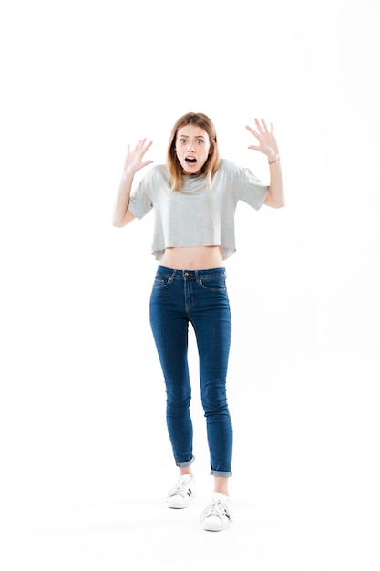 Portrait of a fightened young woman standing and screaming