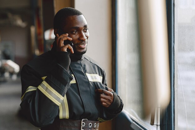 Portrait of a firefighter standing in front of a fire engine